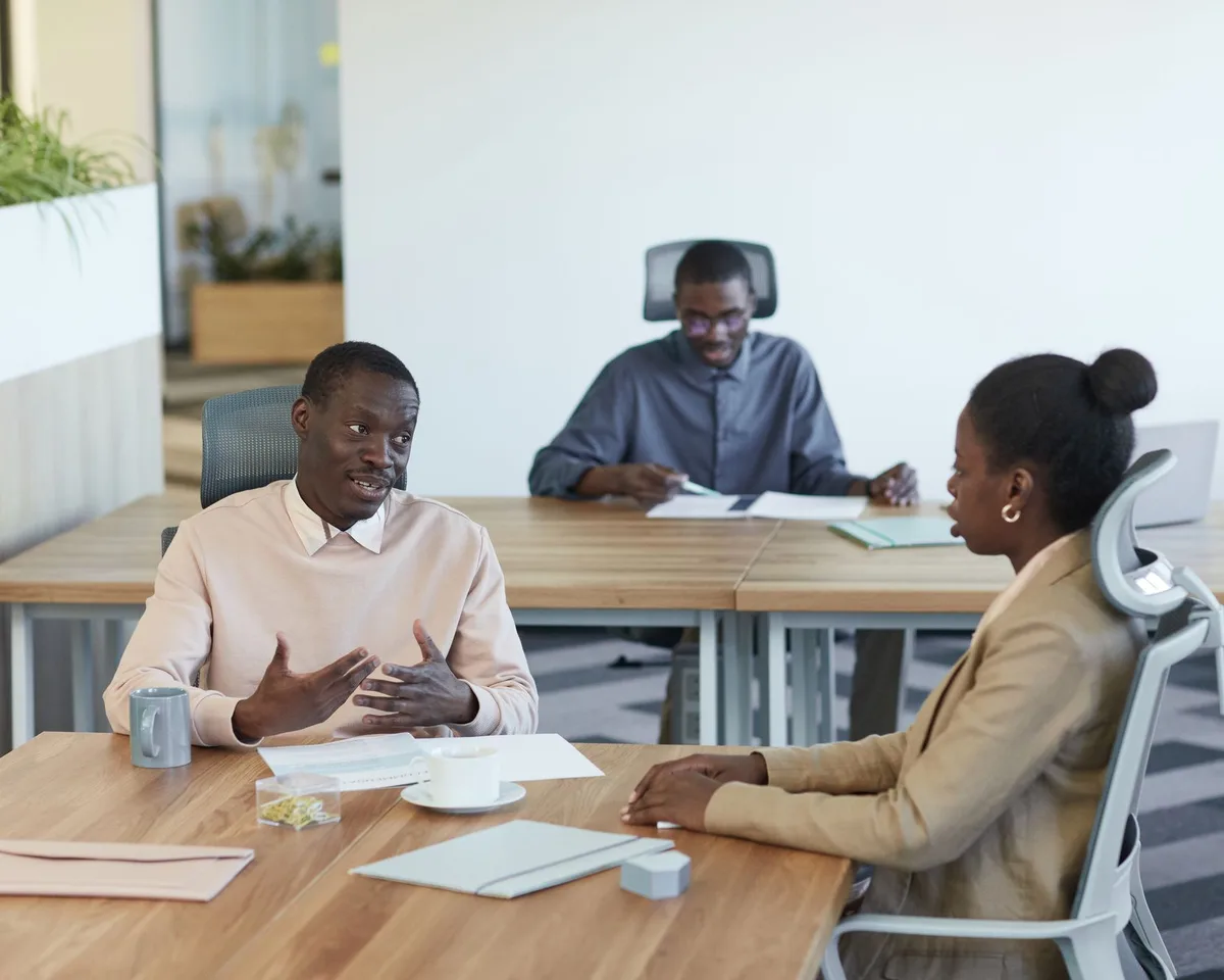 Three colleagues in a meeting in a bright modern office